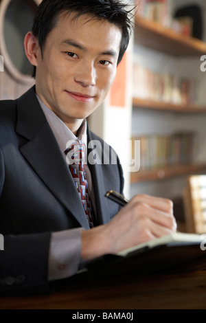 Geschäftsmann Schrift In einem Buch Stockfoto