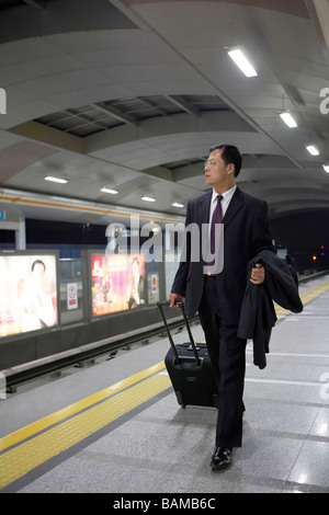Geschäftsmann ziehen Koffer entlang zum Bahnhof Stockfoto