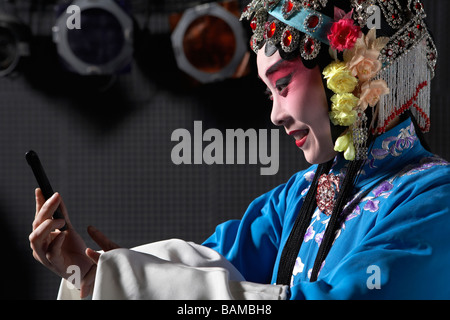 Frau trägt traditionellen Kleidung, hält ein Handy Stockfoto