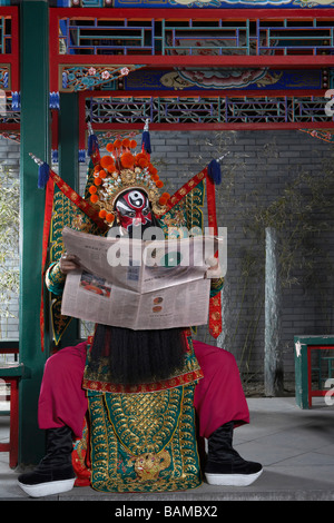 Mann In zeremoniellen Kostüm lesen Zeitung Stockfoto