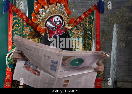 Mann In zeremoniellen Kostüm lesen Zeitung Stockfoto