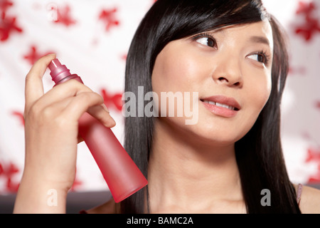 Junge Frauen, die Nebel auf Gesicht Spritzen Stockfoto