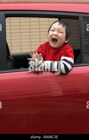 Kleiner Junge Up im Auto spielen Stockfoto