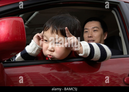 Junges Kind ziehen Gesicht im Auto Stockfoto