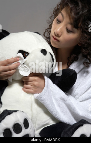 Junge Frau im Bett mit Panda Plüschtier Stockfoto