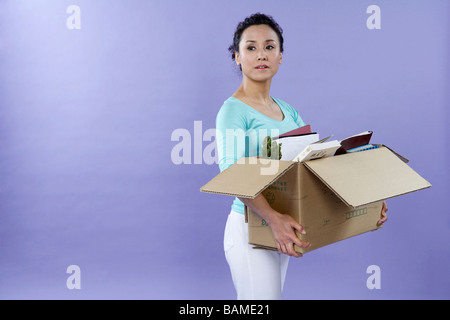 Junge Frau Schreibtisch ausräumen Stockfoto