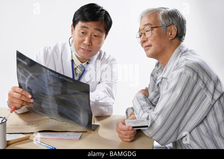 Arzt und Patient, die Überprüfung der Röntgen-Blätter Stockfoto