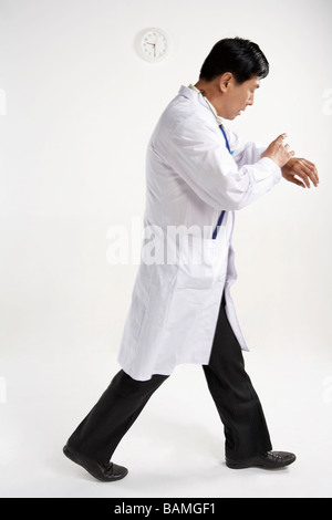 Arzt, Blick auf seine Armbanduhr Stockfoto