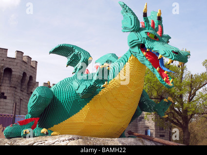 Böse aussehende Full-Size-grüne und gelbe Lego Drachen vor mittelalterlichen Burg Kulisse am Legoland Freizeitpark Stockfoto