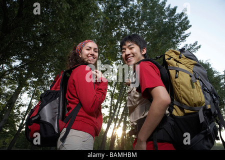 Junge Paare, die durch Bäume Stockfoto