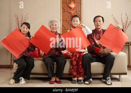 Familie In traditioneller Kleidung Papier hochhalten Stockfoto