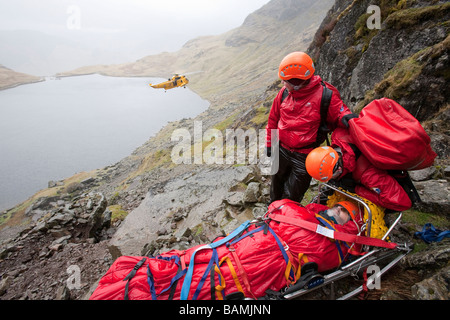 Ein Spaziergänger mit einer zusammengesetzten Bein Fraktur wird von Langdale Ambleside Bergrettung in leicht Gully auf Pavey Arche behandelt. Stockfoto