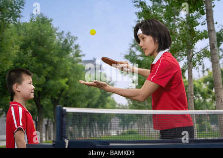 Mutter zeigt Sohn wie Ping-Pong spielen Stockfoto