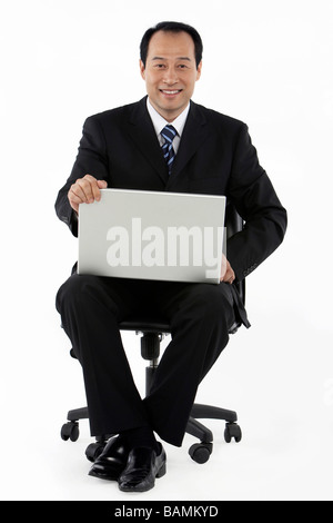 Geschäftsmann mit einem Laptop und lächelnd Stockfoto