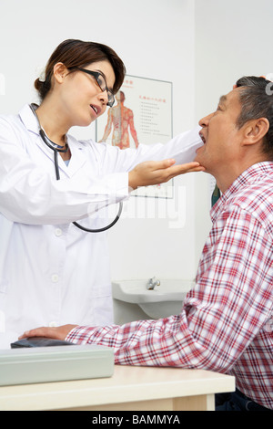 Überprüfung des Patienten Kehle Arzt Stockfoto