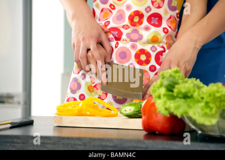 Junges Paar Schneiden von Gemüse In der Küche Stockfoto