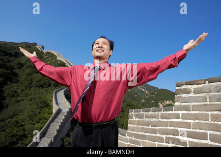 Geschäftsmann, stehen auf der Great Wall Of China, erhobenen Armen Stockfoto