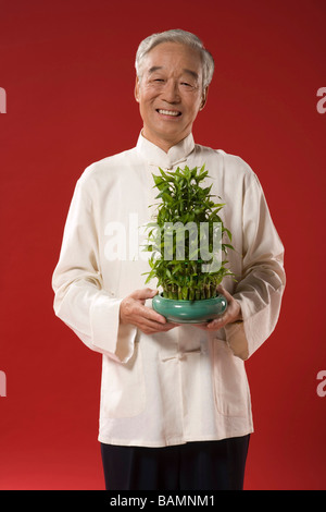 Älterer Mann mit kleinen Bambus Stockfoto