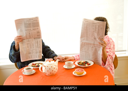 Mann und Frau am Frühstückstisch mit Zeitungen Stockfoto