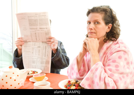 Mann und Frau am Frühstückstisch mit Zeitungen Stockfoto