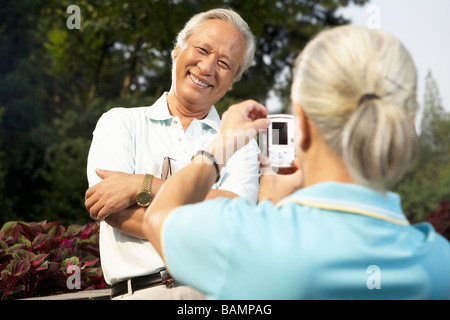 Frau mit digitalen fotografieren ihres Ehemannes Stockfoto