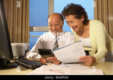 Unternehmer und Business-Frau, Lächeln, mit Blick auf Rechner Stockfoto