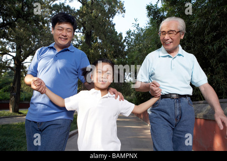 Kleines Mädchen mit Vater und Großvater durch den Park zu Fuß Stockfoto