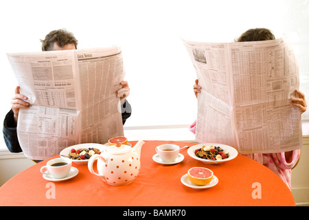 Mann und Frau am Frühstückstisch mit Zeitungen Stockfoto