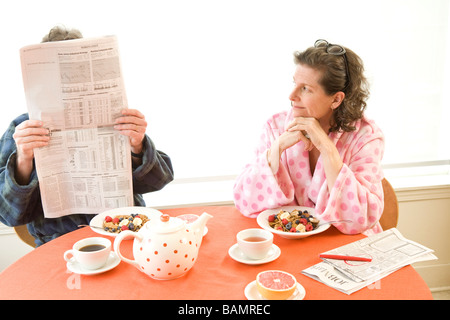 Mann und Frau am Frühstückstisch mit Zeitungen Stockfoto