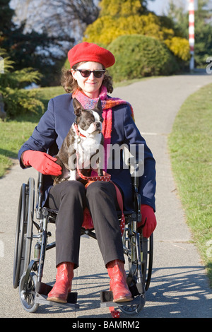 Frau im Rollstuhl mit Hund auf dem Schoß Stockfoto