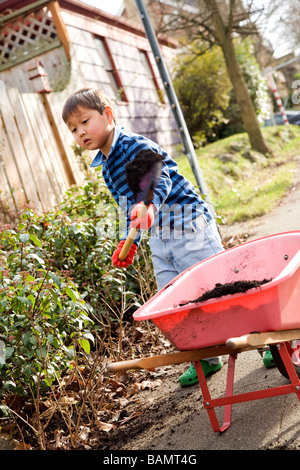 Kleiner Junge, der im Garten arbeitet Stockfoto