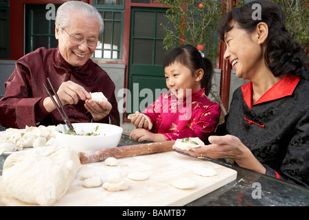 Familie Making Knödel im Innenhof Stockfoto