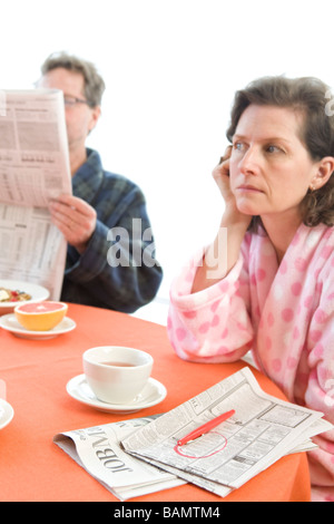 Mann und Frau am Frühstückstisch mit Zeitungen Stockfoto