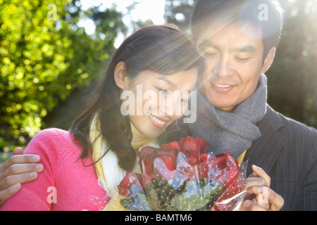 Junger Mann mit Blumen, Freundin Stockfoto
