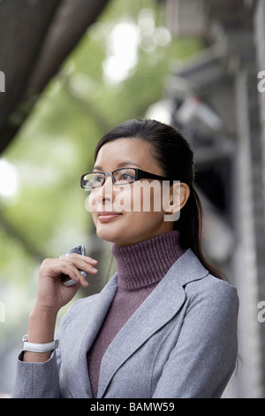 Businesswoman Holding ein Handy Stockfoto