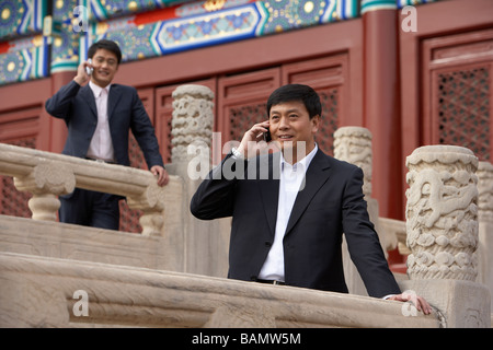 Zwei Geschäftsleute sprechen auf Handys In der verbotenen Stadt In Peking Stockfoto