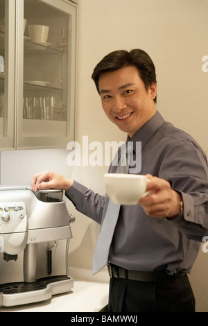 Junger Mann, die Zubereitung von Kaffee im Büro Stockfoto