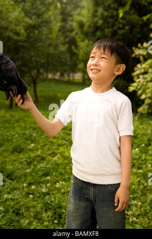 Kleiner Junge hält ein Tier Pfote Stockfoto