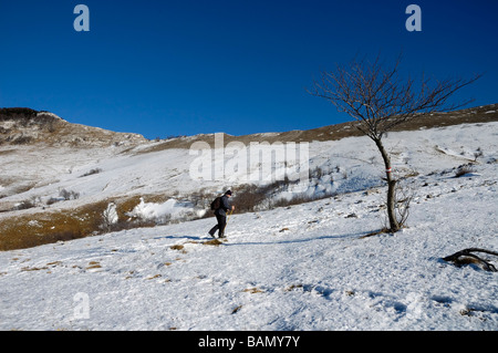 Ein Bergsteiger unter dem Berg bedeckt mit Schnee, während die hellen, sonnigen Tag Stockfoto