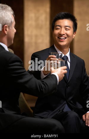 Zwei Führungskräfte teilen einen Toast in einem exklusiven Business-club Stockfoto