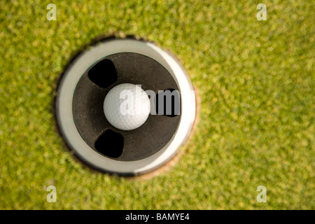 Golfball im Loch Stockfoto