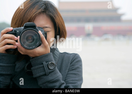 Junge Frau, die ein Foto vor dem Tiananmen-Platz, Peking, China Stockfoto