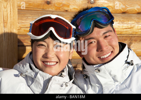 Junger Mann und junge Frau in Skibrillen lächelnd in die Kamera Stockfoto