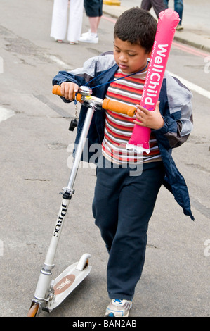Ein Junge mit einem Roller bei London Marathon 2009, England, UK Stockfoto