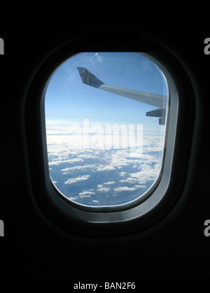 Flügel und Himmel in großer Höhe durch das Fenster ein Passagierflugzeug jet Stockfoto