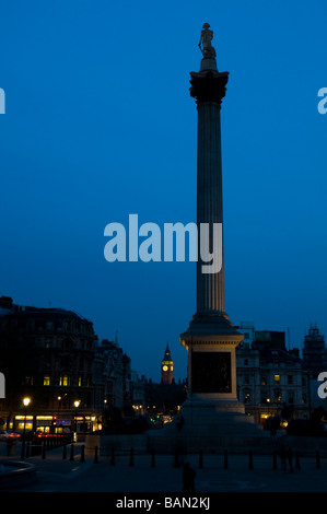 Nelson Säule auf dem Trafalgar Square in der Nacht mit Big Ben im Hintergrund Stockfoto