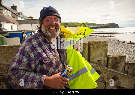 Lachen, bärtigen Fischer hält eine Dose Fosters Lager am Strand von Borth Ceredigion West Wales UK Stockfoto