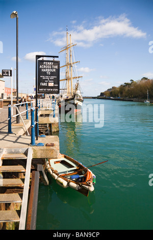 Blick entlang der Uferstraße, Hafen von Weymouth, Dorset, UK.  Ruderboot und Ausbildung Großsegler - The Pelican of London mit der Fähre. Stockfoto