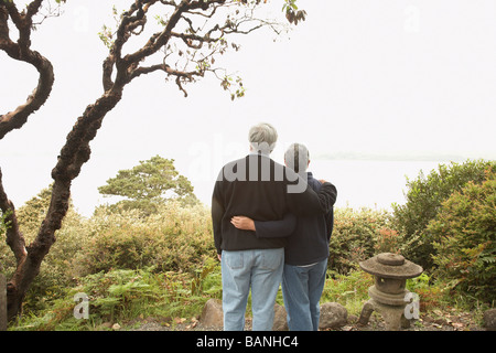 Älteres paar stehende Arm in Arm im freien Stockfoto