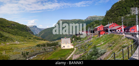 Panorama einen malerischen Berg sightseeing tour Bahnhof Sommer Saison Passagiere warten außerhalb des roten Gebäude Berggipfel blauer Himmel Stockfoto